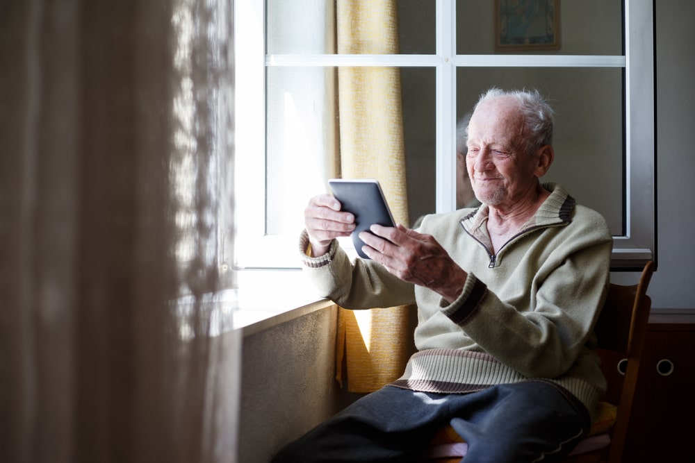 Anciano con tablet en mano
